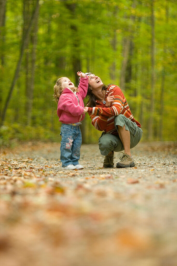 Young woman and child exploring in forest in rural Lake Ossipee, New Hampshire New Hampshire, United States