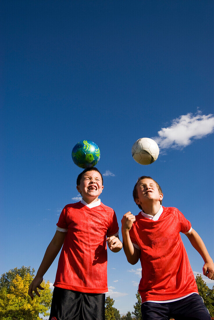 Two boys do a header with the soccer ball in Fort Collins, Colorado Fort Collins, Colorado, USA