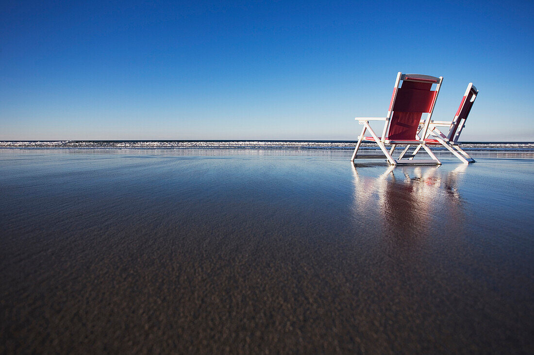 Two beach chairs on wet sand in York, Maine York, Maine, United States of America