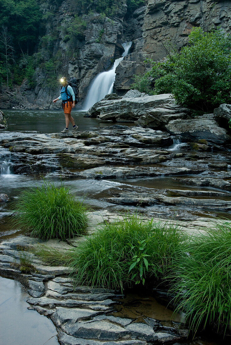 Woman standing below Linville Falls with headlamp, Pisgah National Forest, North Carolina Spruce Pine, North Carolina, USA