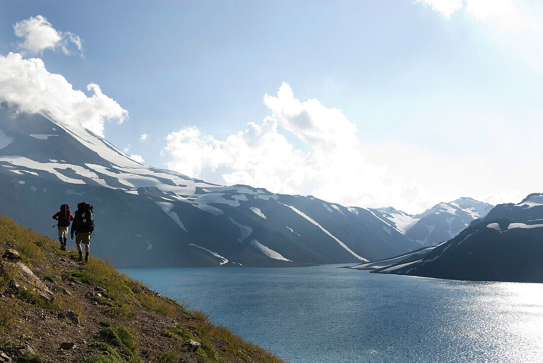 Two backpackers follow a trail around an alpine lake near the border of Chile and Argentina Chile