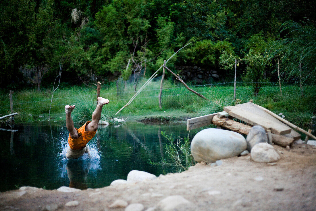 A young man dives into a small swimming hole Chile