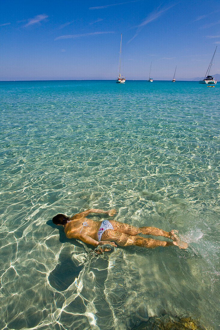 A young woman swims underwater in a crystal clear sea in front of the Saleccia Beach, Corse, France Casta, Corse, France