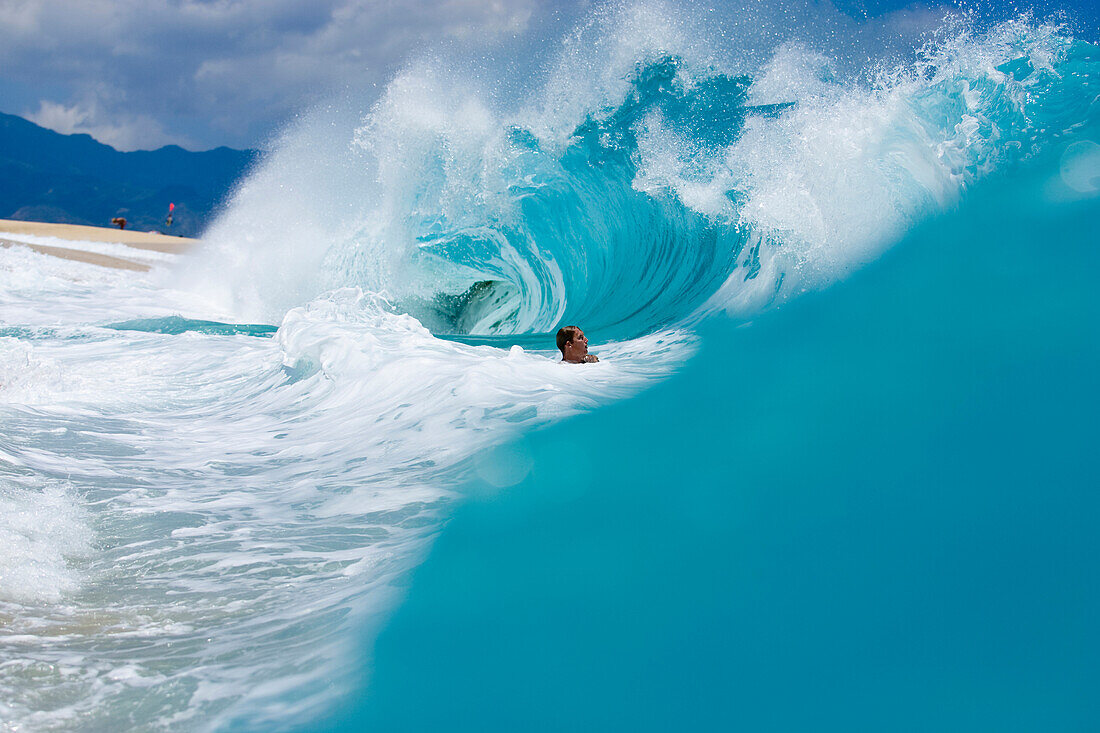 A young man body surfing at Keiki Beach on the North Shore of Oahu, Hawaii North Shore, Oahu, Hawaii, USA