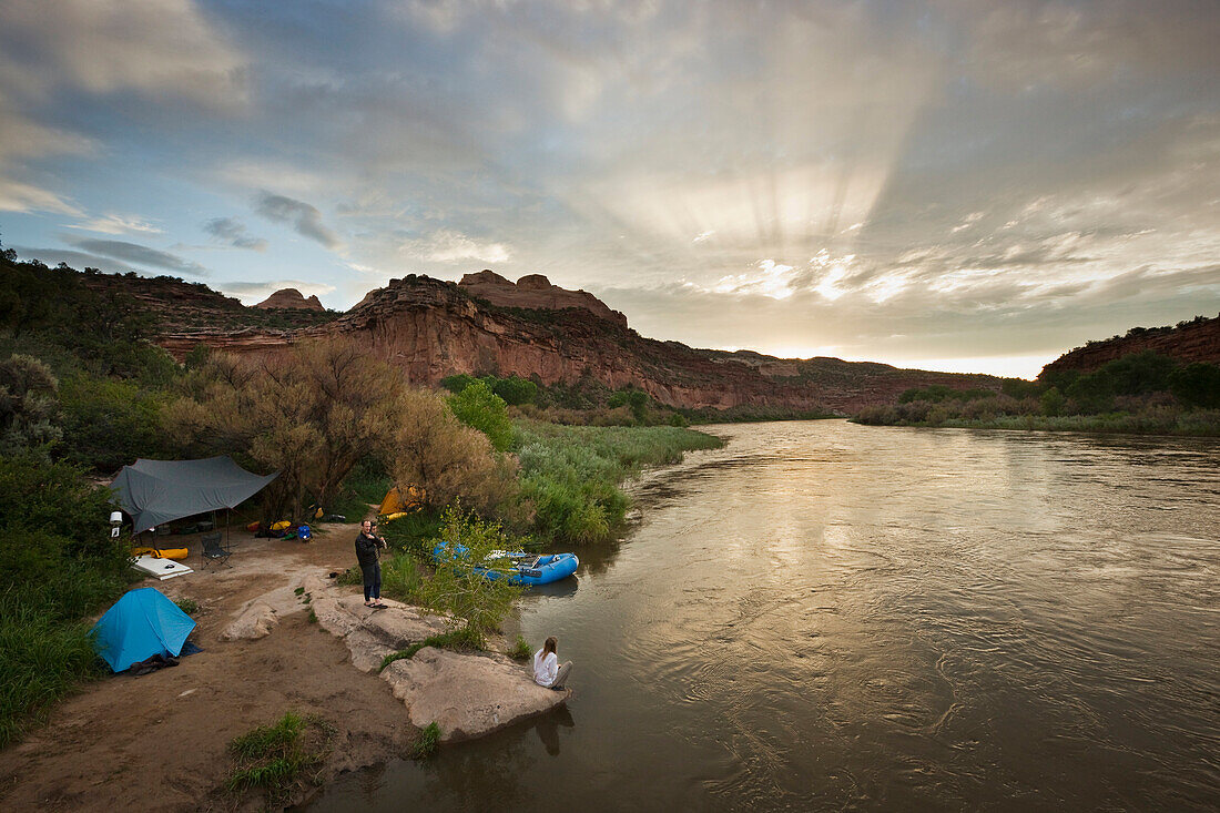 A group of people camp after rafting on the Colorado River at sunset Grand Junction, Colorado, USA