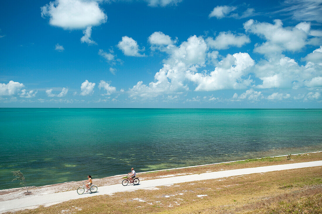 A man and woman ride bicycles in Florida Key West, Florida, USA