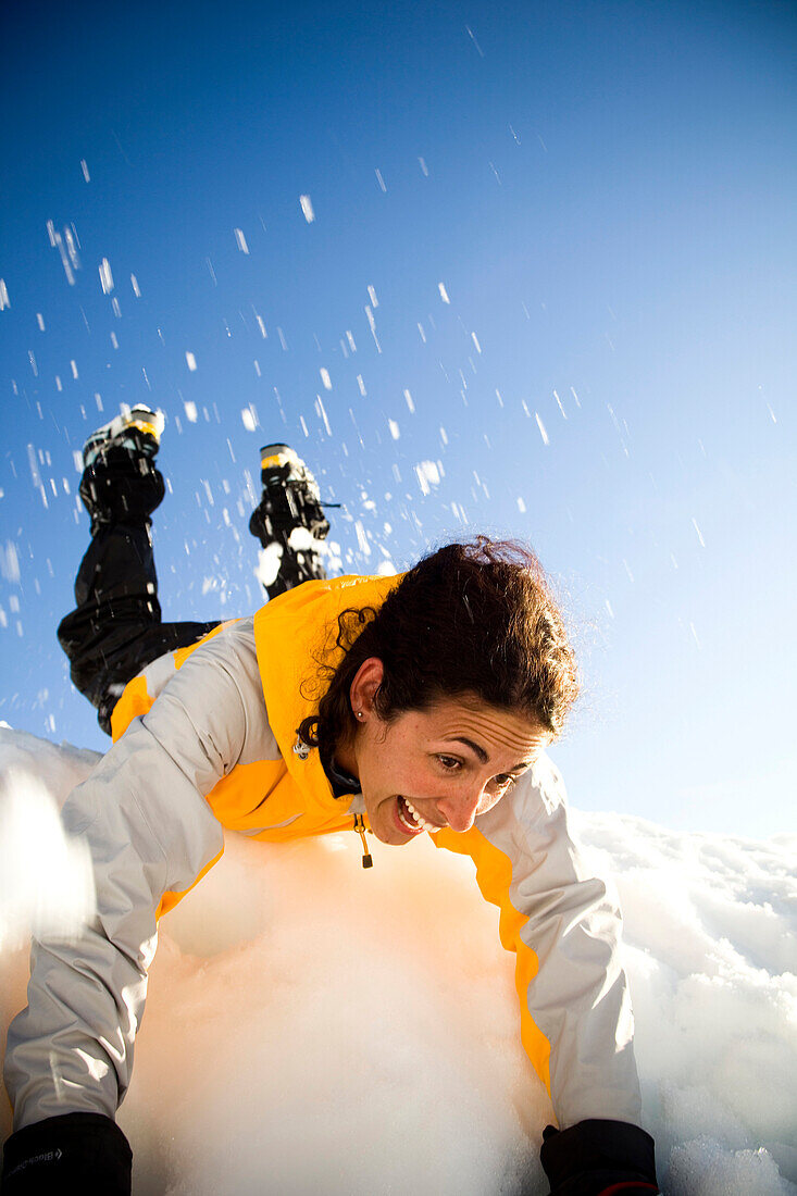 A Latina woman on a snow slide in the mountains, North Cascades National Park, Washington, USA
