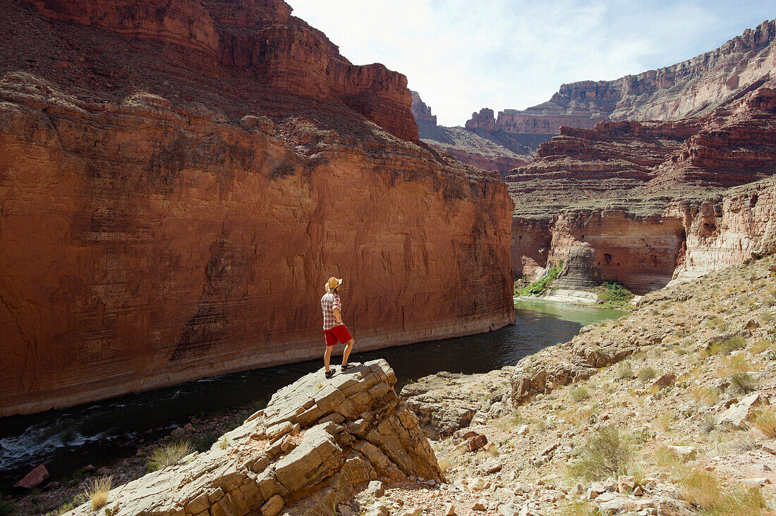 A young woman takes in the view above the Colorado River at the Grand Canyon in Arizona Arizona, USA