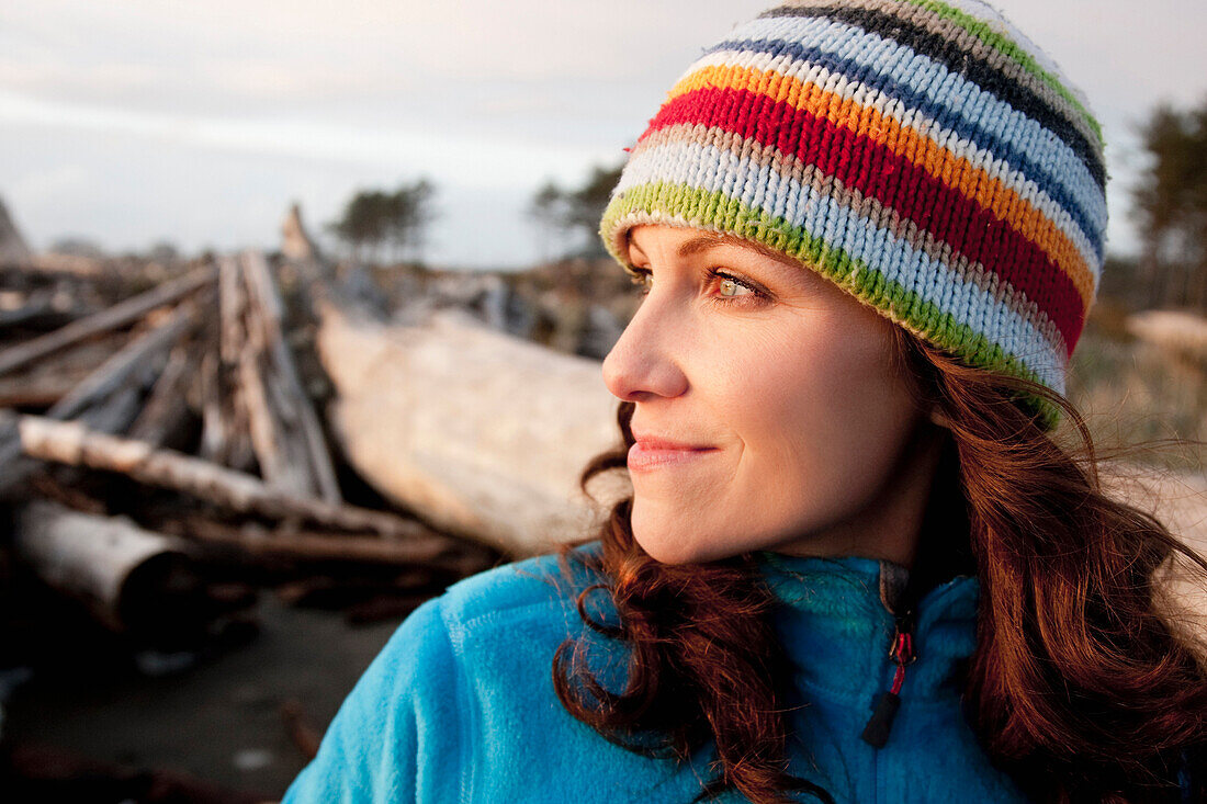 A young  woman watching the sunset on the coast La Push, Washington, USA