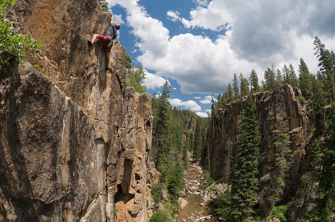 A young man rock climbing in the San Juan National Forest, Durango, Colorado Durango, Colorado, USA