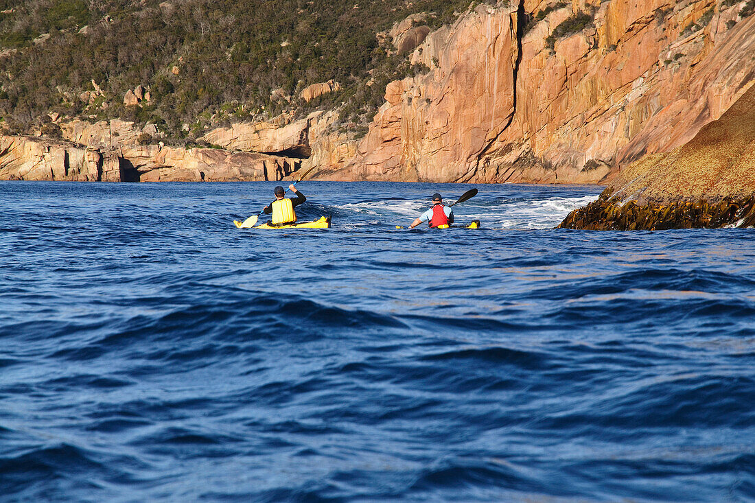 Two sea kayakers are exploring Schouten Island, Freycinet National Park, Tasmania, Australia Freycinet National Park, Tasmania, Australia