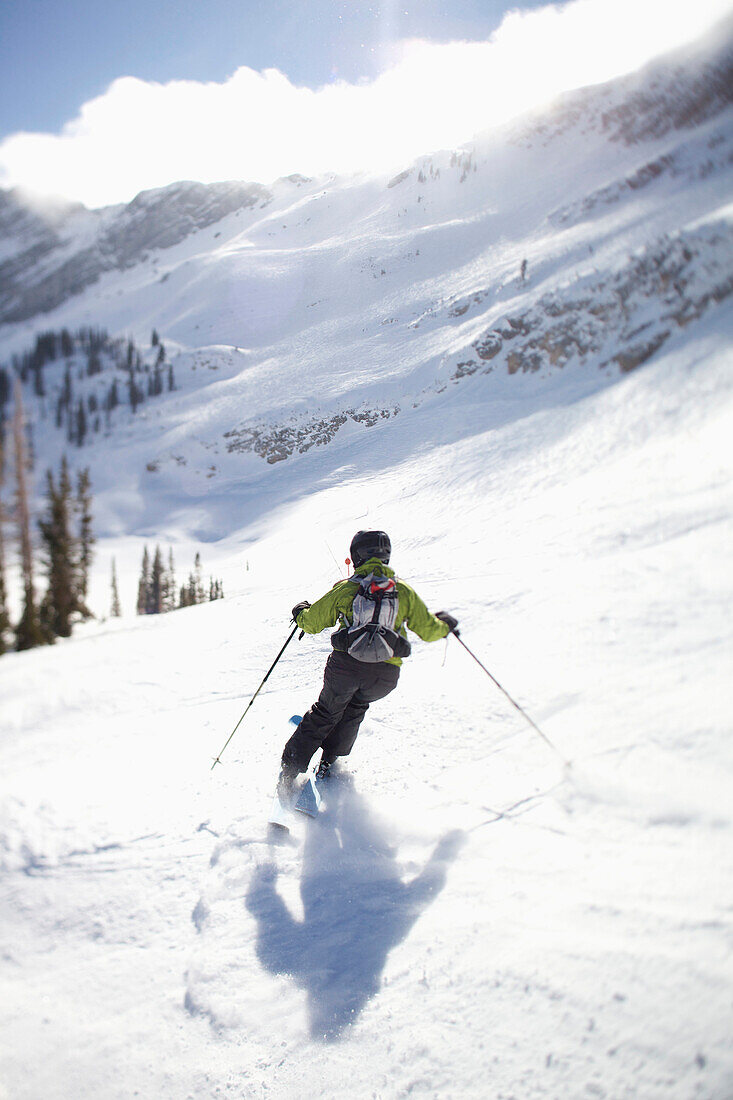 A woman skis in Utah under bright, blue skies Salt Lake City, Utah, USA