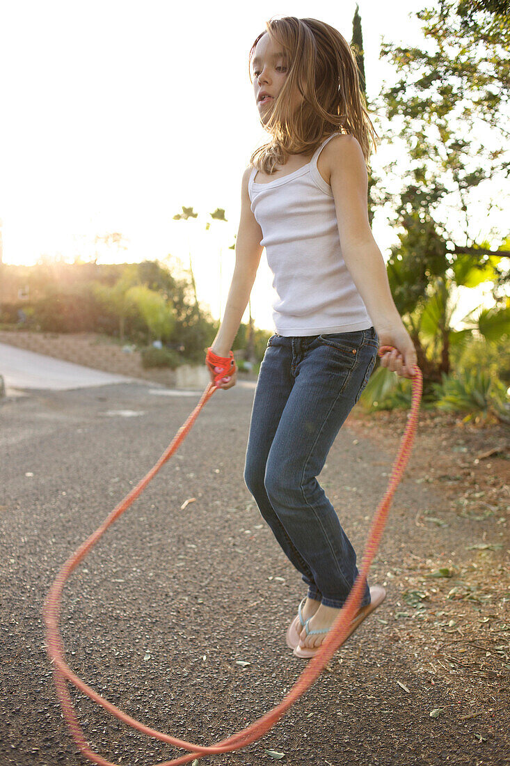 Young girl jumping rope on the street San Diego, California, USA