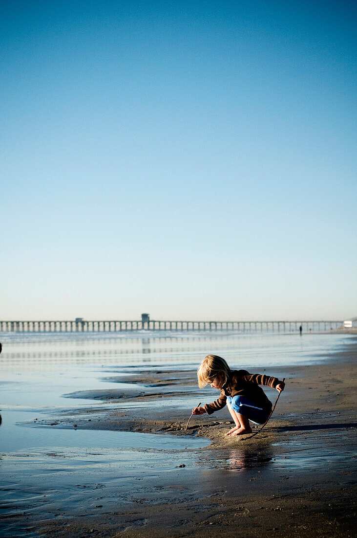 A young girl plays at the beach Oceanside, California, USA