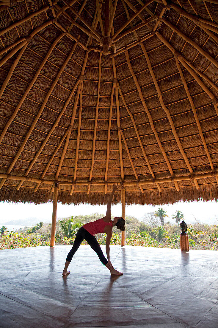 A woman practicing yoga in a pavilion overlooking Sayulita Puerto Vallarta, Mexico