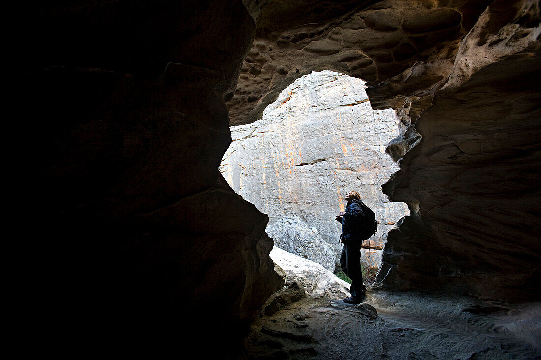Man standing in the light of the entrance to cave Victoria, Australia