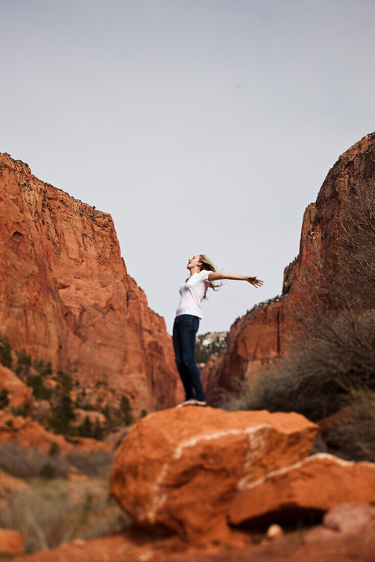 A women balances on a rock in Utah Zion National Park, Utah, USA