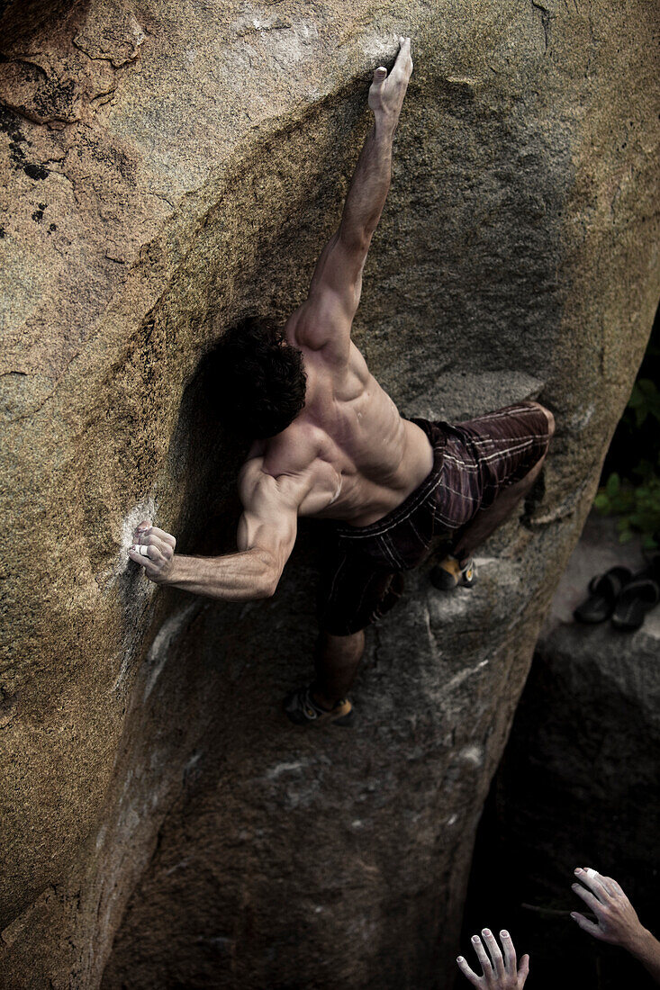 A muscular climber reaches into a difficult move in Hampi, India Hampi, Karnataka, India
