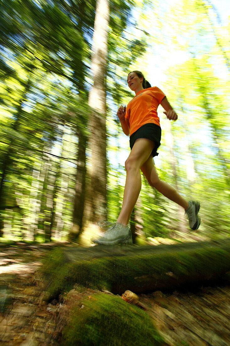 Woman trail running in a lush green forest, Fayetteville, West Virginia, USA