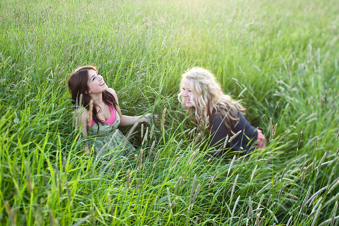 Girls sit in a grassy field in Sandpoint, Idaho Sandpoint, Idaho, USA