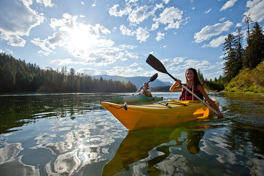 Young adult couple kayak on a beautiful summer day in Idaho Sandpoint, Idaho, USA