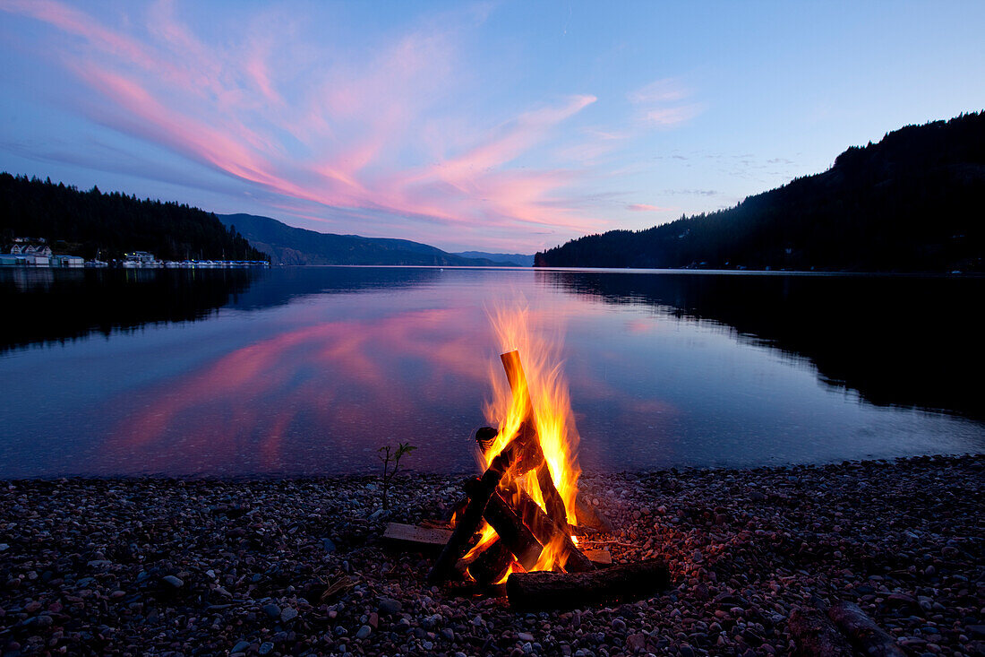 Campfire with sunset reflected on the lake in Idaho Sandpoint, Idaho, USA