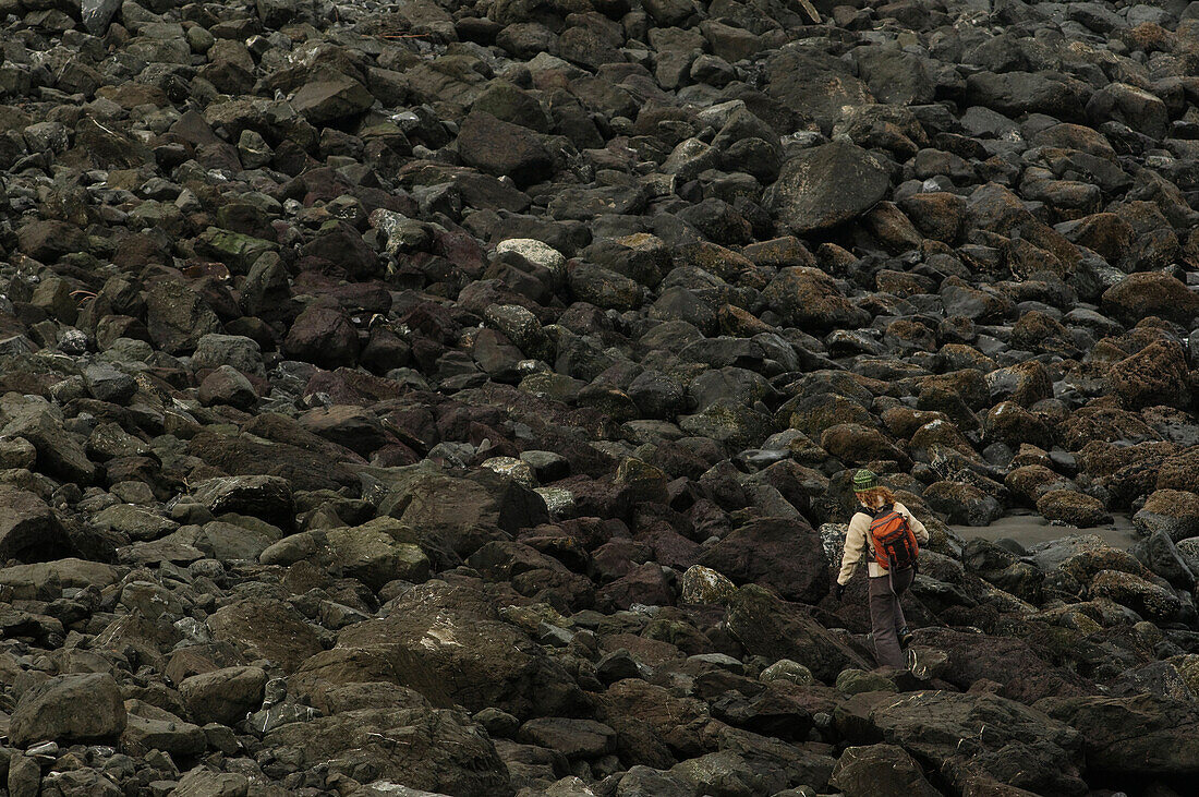 A woman hikes on a beach on the Oregon Coast Port Orford, Oregon, USA