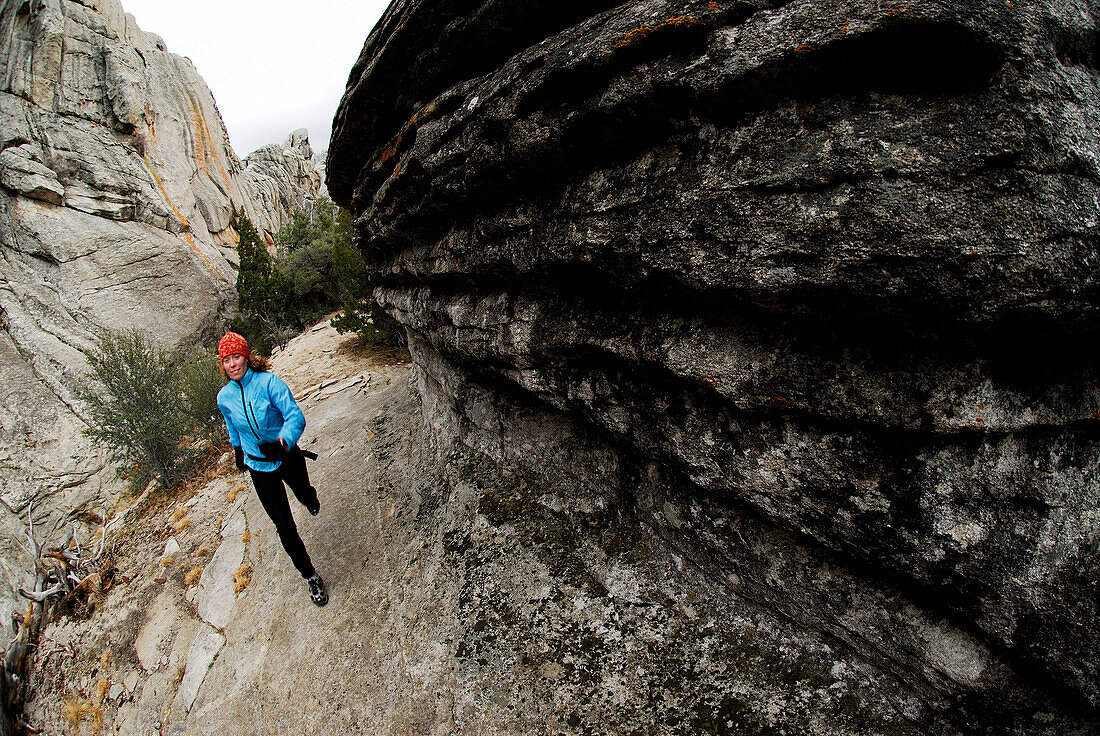 A woman trail running through a canyon City of Rocks, Idaho, USA