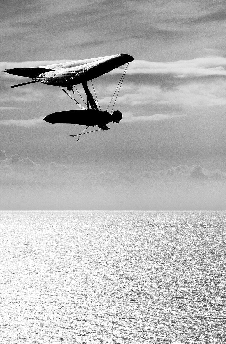 A man soars above the pacific ocean in a hang glider Santa Barbara, California, USA