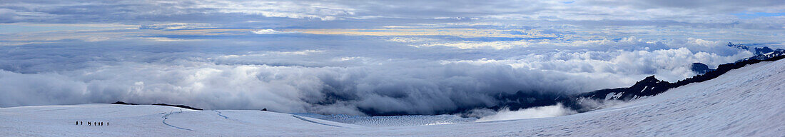 Mountaineering group descending Hvanadalshnukur mountain in Iceland above clouds, Skaftafell National Park, southern coastal region, Iceland