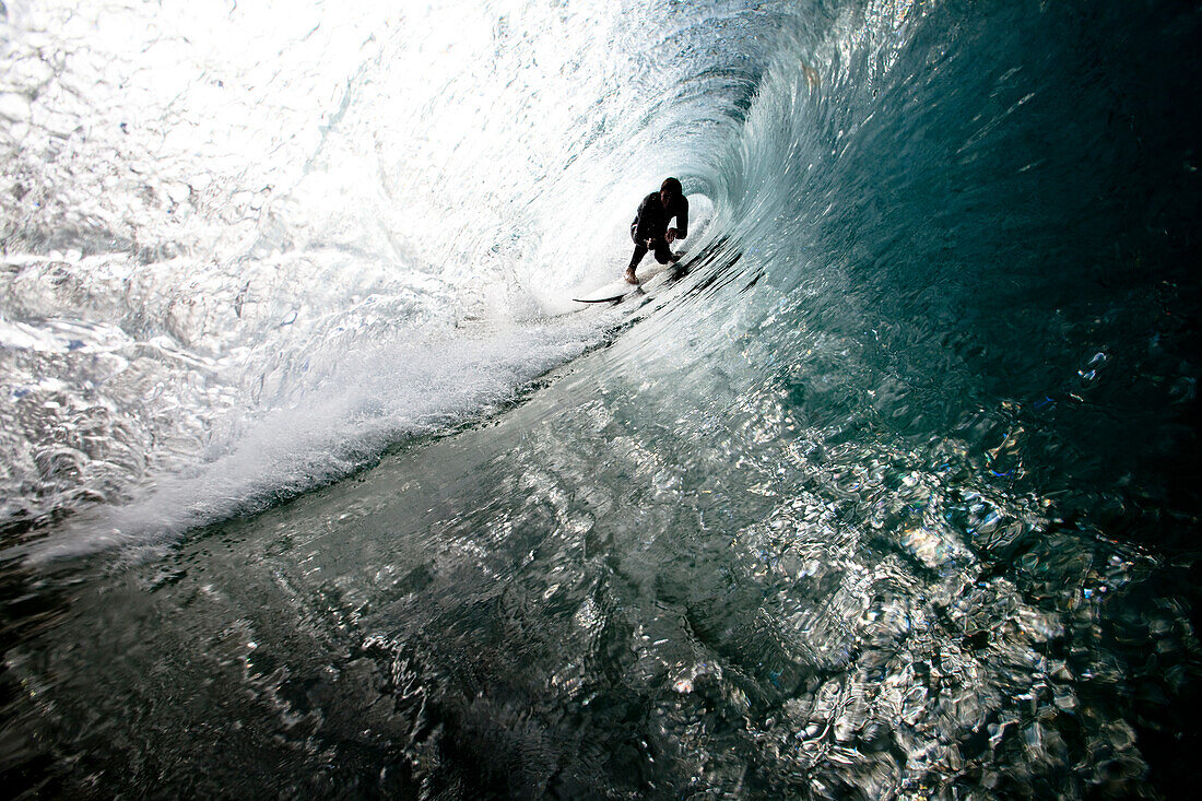 A male surfer navigates the barrel while surfing at Westward in Malibu, California Malibu, California, United States of America