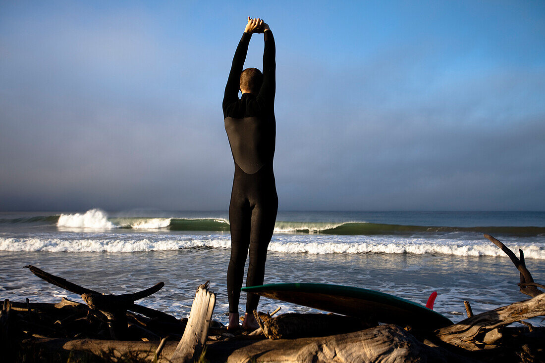 A teenage male stretches before he goes surfing in Ventura, California Ventura, California, United States of America