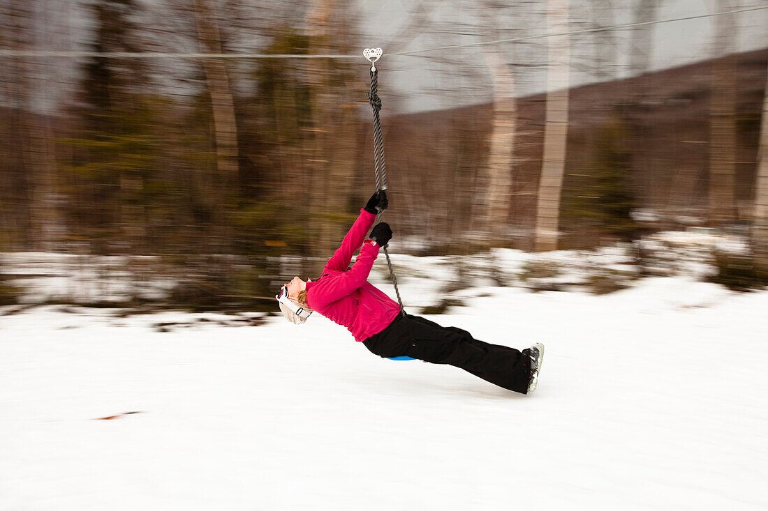 A woman plays on a zip line in Bretton Woods, New Hampshire. Blurred motion Bretton Woods, New Hampshire, United States of America