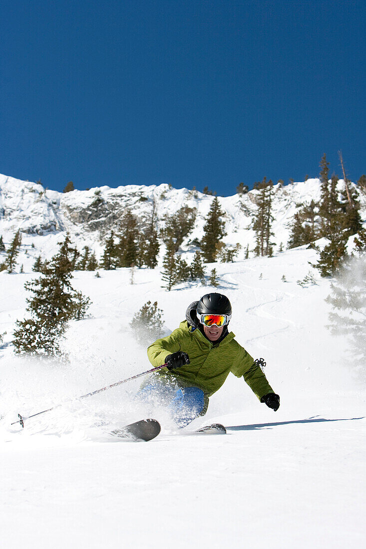A man skiing fresh untracked snow on a bluebird day Utah, USA