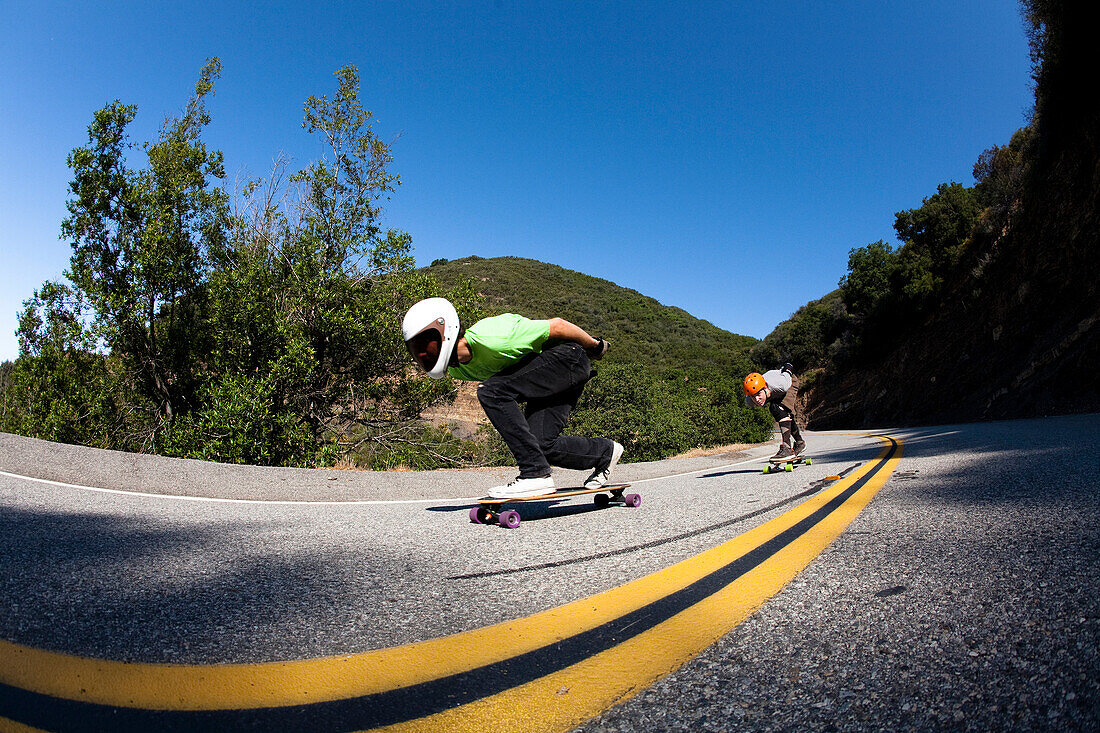 Two downhill skateboarders ride down a steep mountain road Malibu, California, United States of America