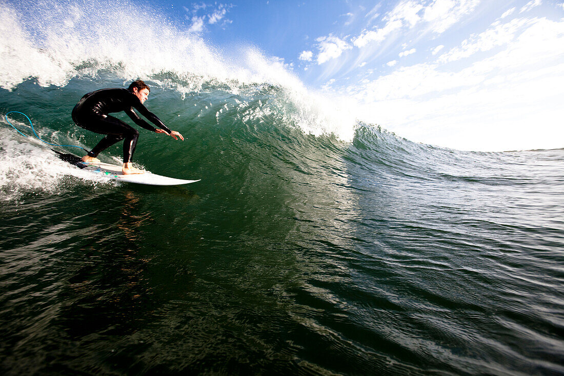 A male surfer does a bottom turn while surfing in Malibu Malibu, California, United States of America