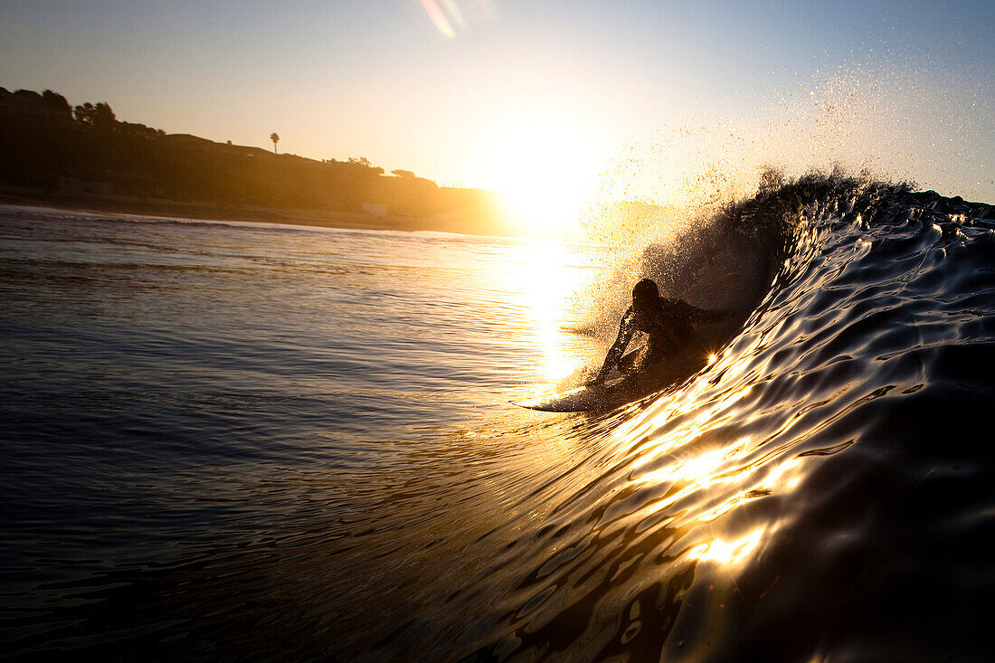 A male surfer pulls into a barrel at Zuma beach in Malibu, California Malibu, California, United States of America
