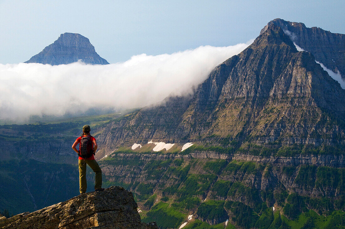 A female hiker takes in the view on the Highline Trail  in Glacier National Park, Montana Glacier National Park, Montana, USA