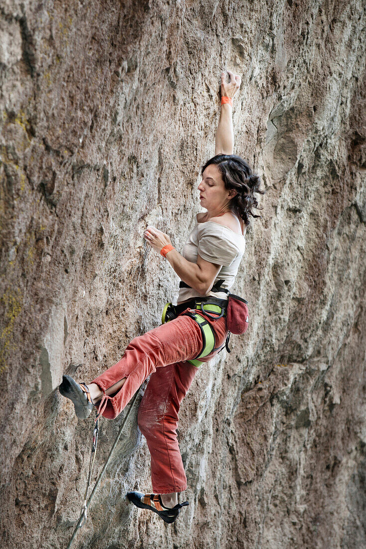A middle aged woman wearing white tshirt and red pants rock climbing in Jilotepec, Estado de Mexico, Mexico Not applicable, Estado de Mexico, Mexico