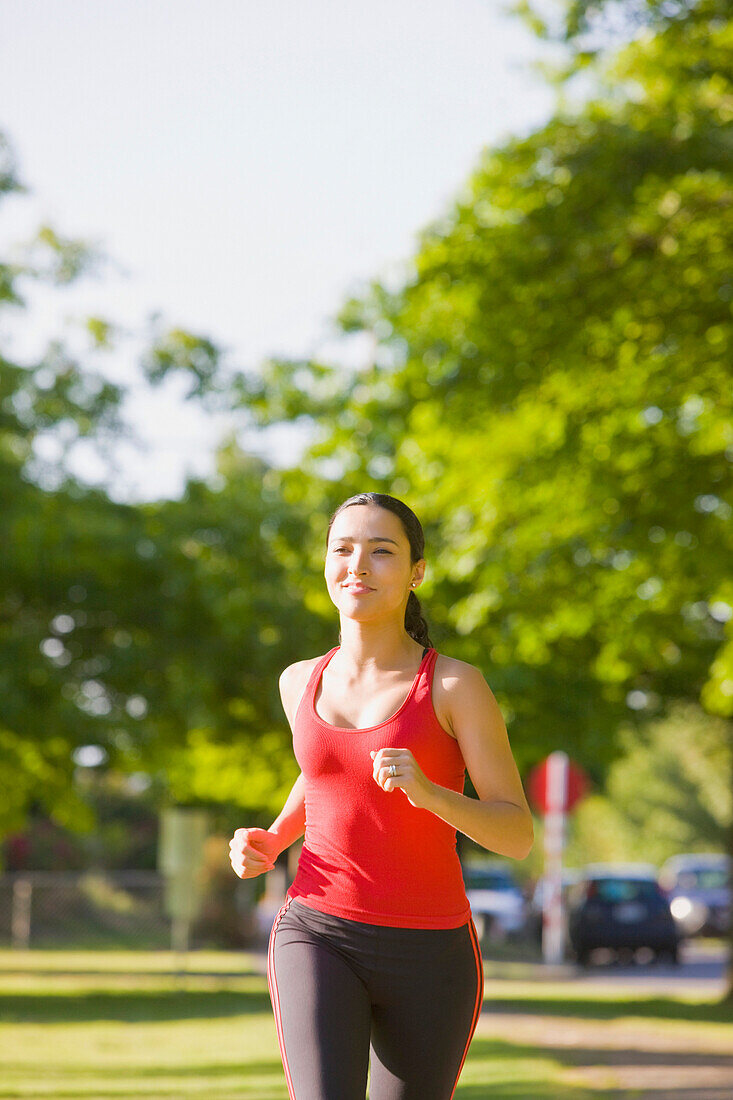 Hispanic woman jogging in park, Seattle, WA