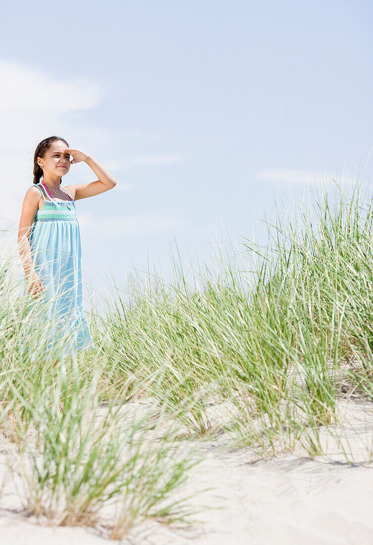 Hispanic girl viewing scenery at beach, Rockaway Beach, NY