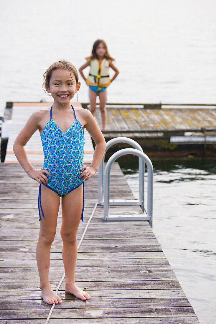 Asian girls standing on dock, Bellingham, WA