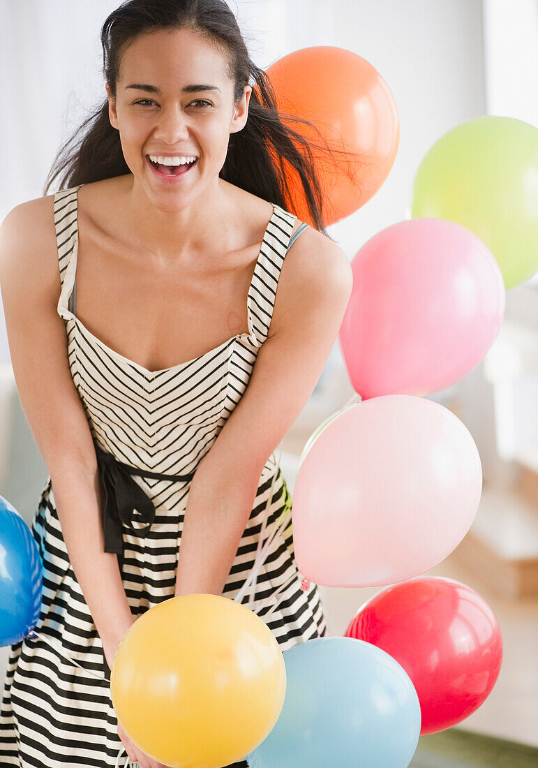 Laughing mixed race woman with balloons, Jersey City, New Jersey