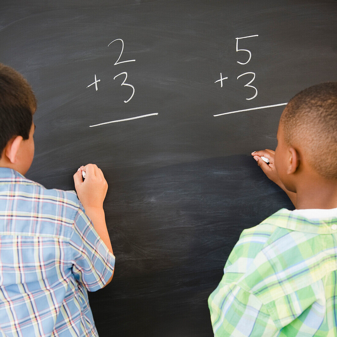 Boys solving math problems on blackboard, Jersey City, New Jersey, USA