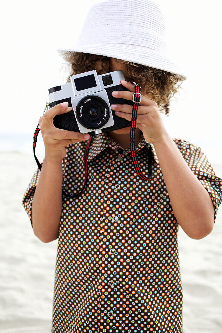 Mixed race boy using old-fashioned camera, San Diego, CA, USA