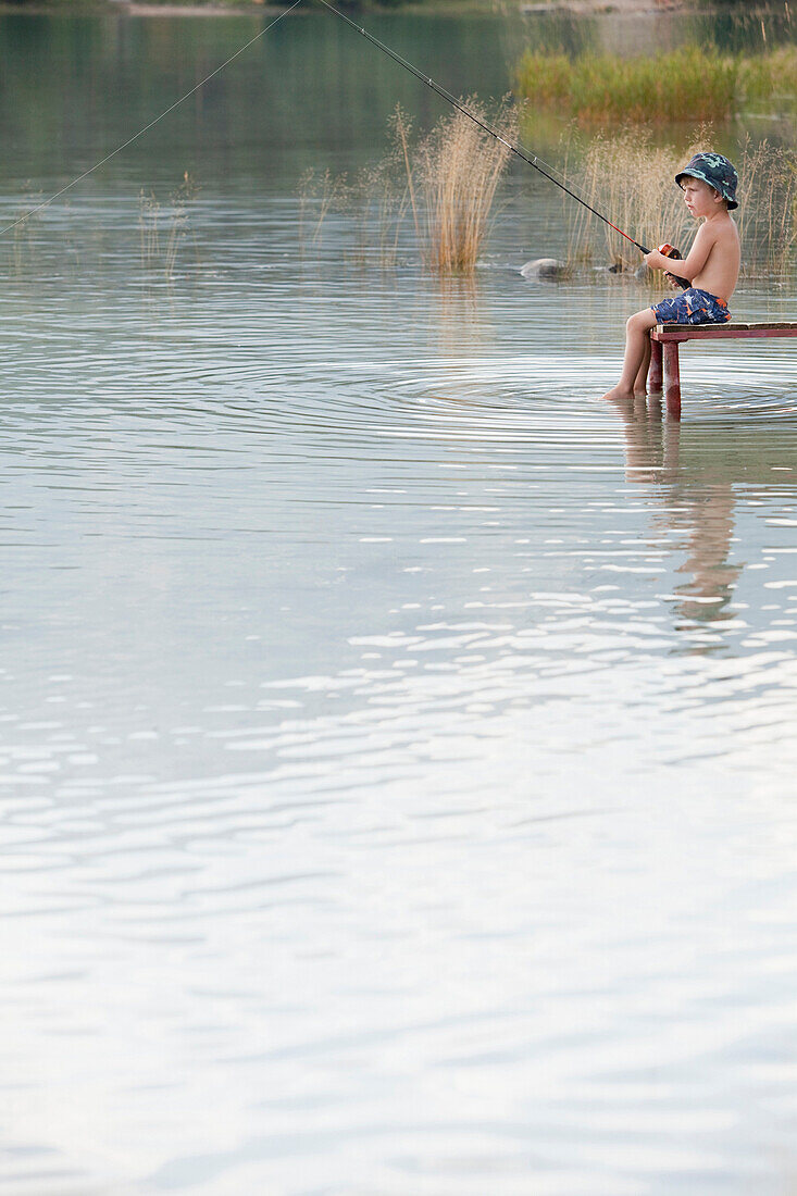 Caucasian boy fishing in lake, Jasper, Alberta, Canada