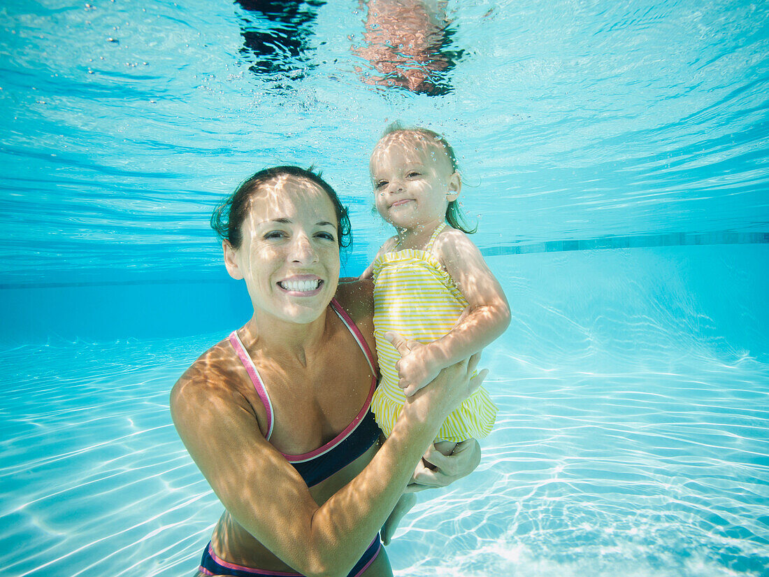 Mother underwater in swimming pool with daughter, Ladera Ranch, CA, USA