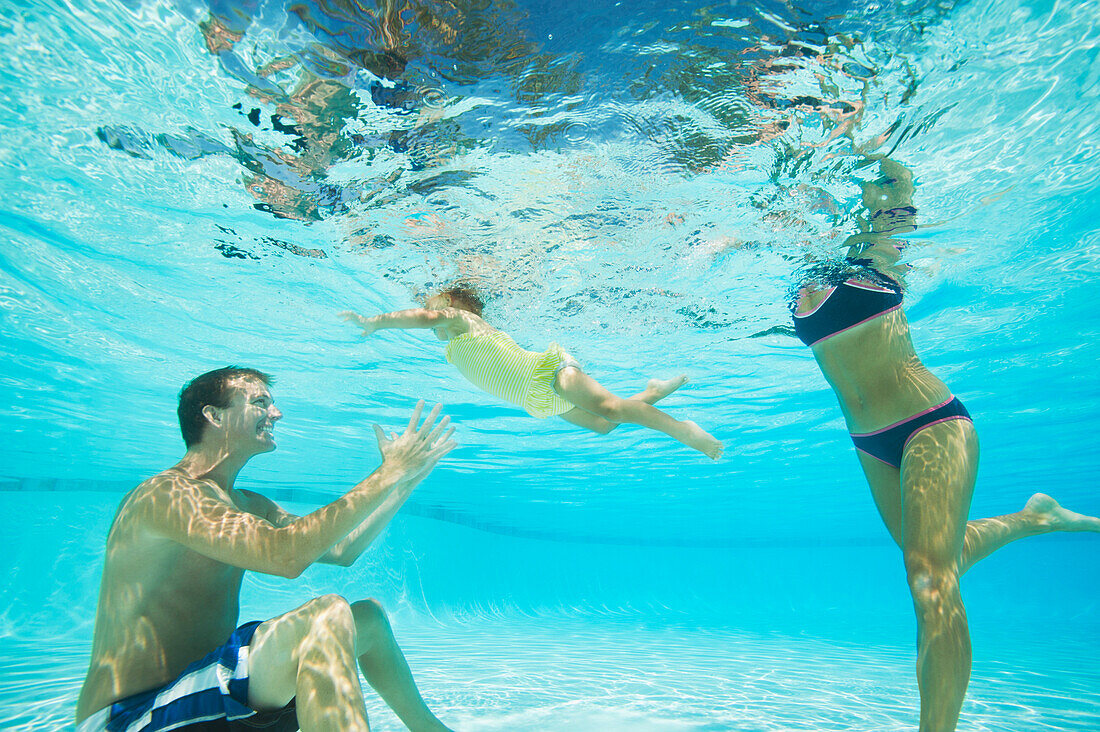 Eltern schwimmen mit ihrer Tochter im Swimmingpool, Ladera Ranch, CA, USA