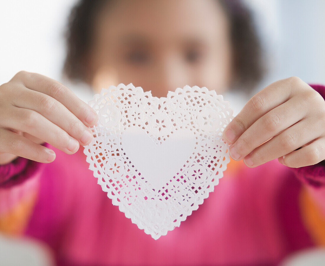 African American girl holding heart-shaped doily, Jersey City, New Jersey, USA