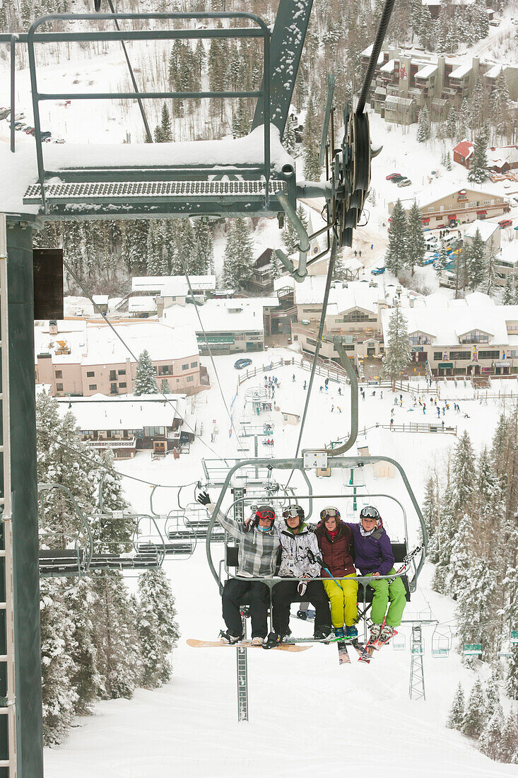 Friends riding ski lift, Taos, New Mexico, USA